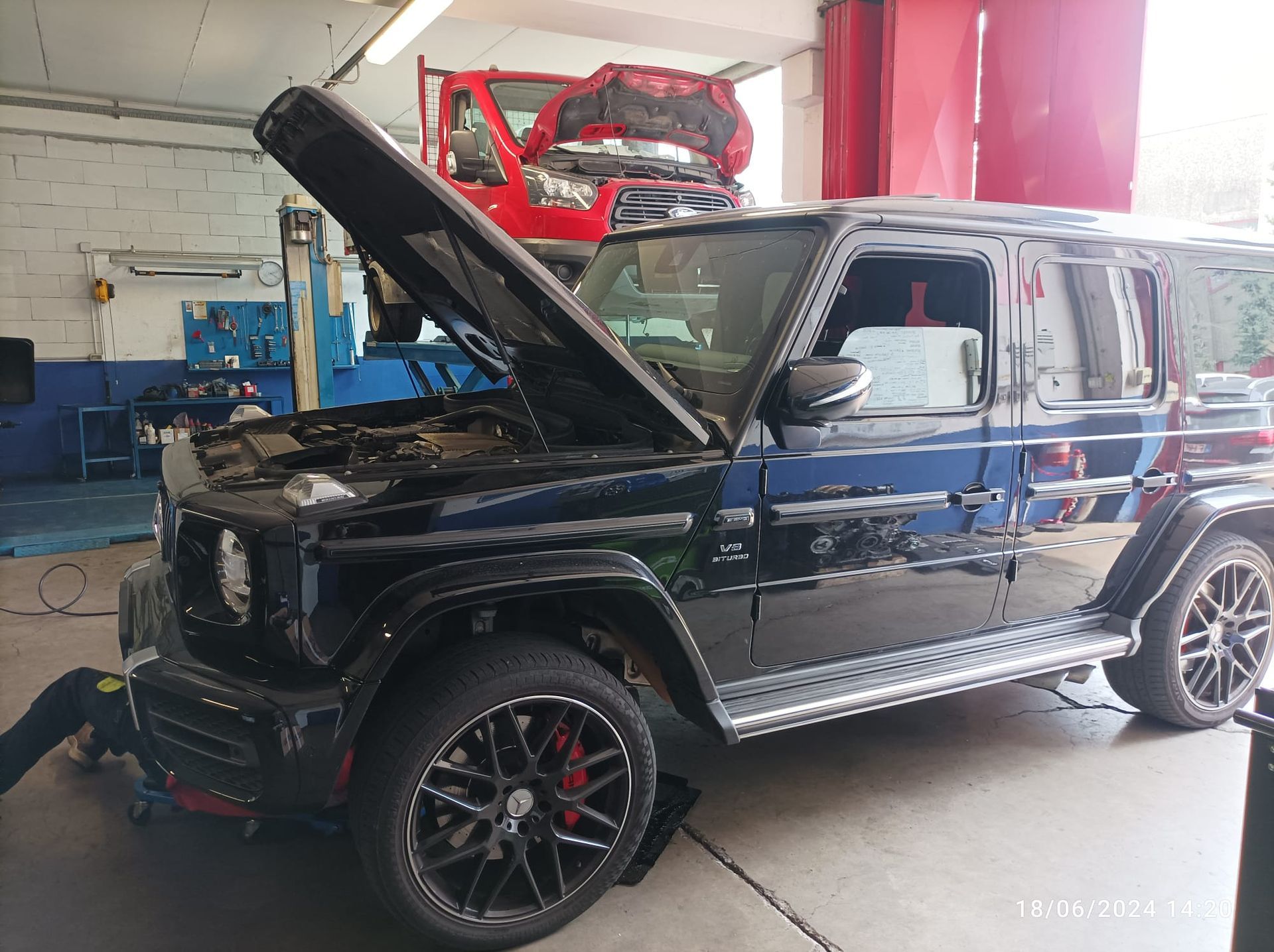 Una jeep nera con il cofano alzato in un garage