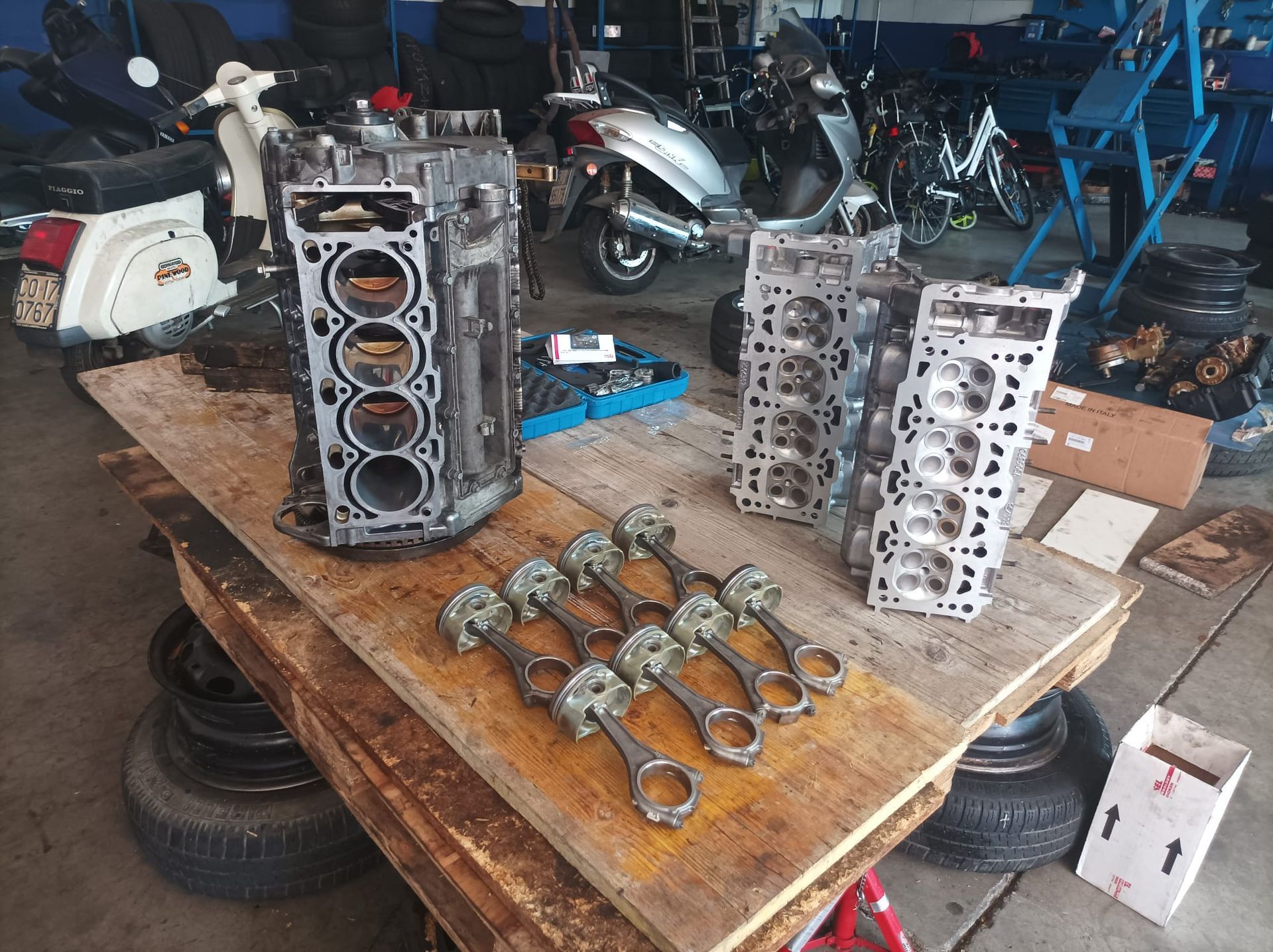 Un tavolo con un mucchio di pezzi di motore sopra