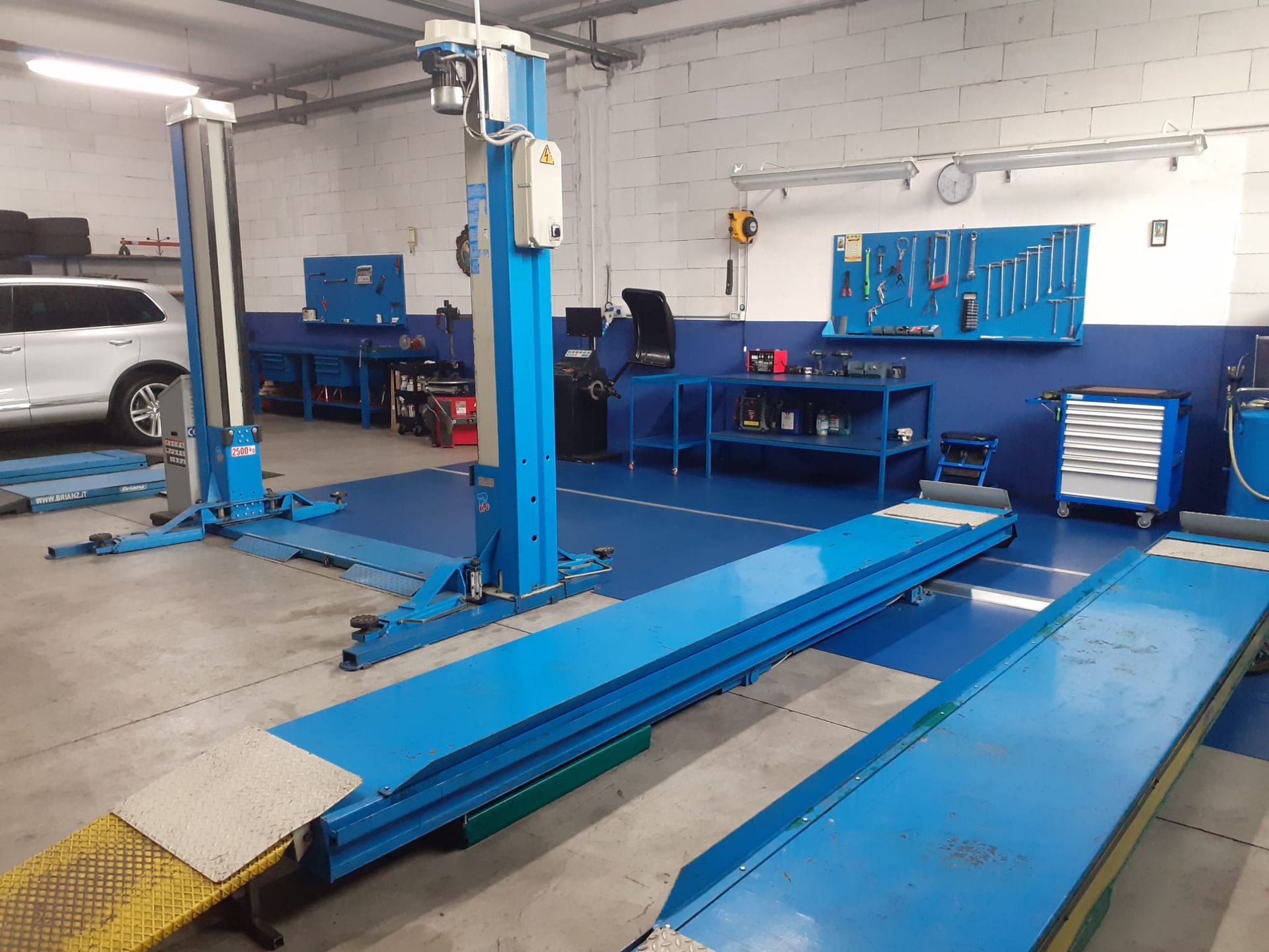 Un garage blu con un SUV bianco parcheggiato sullo sfondo