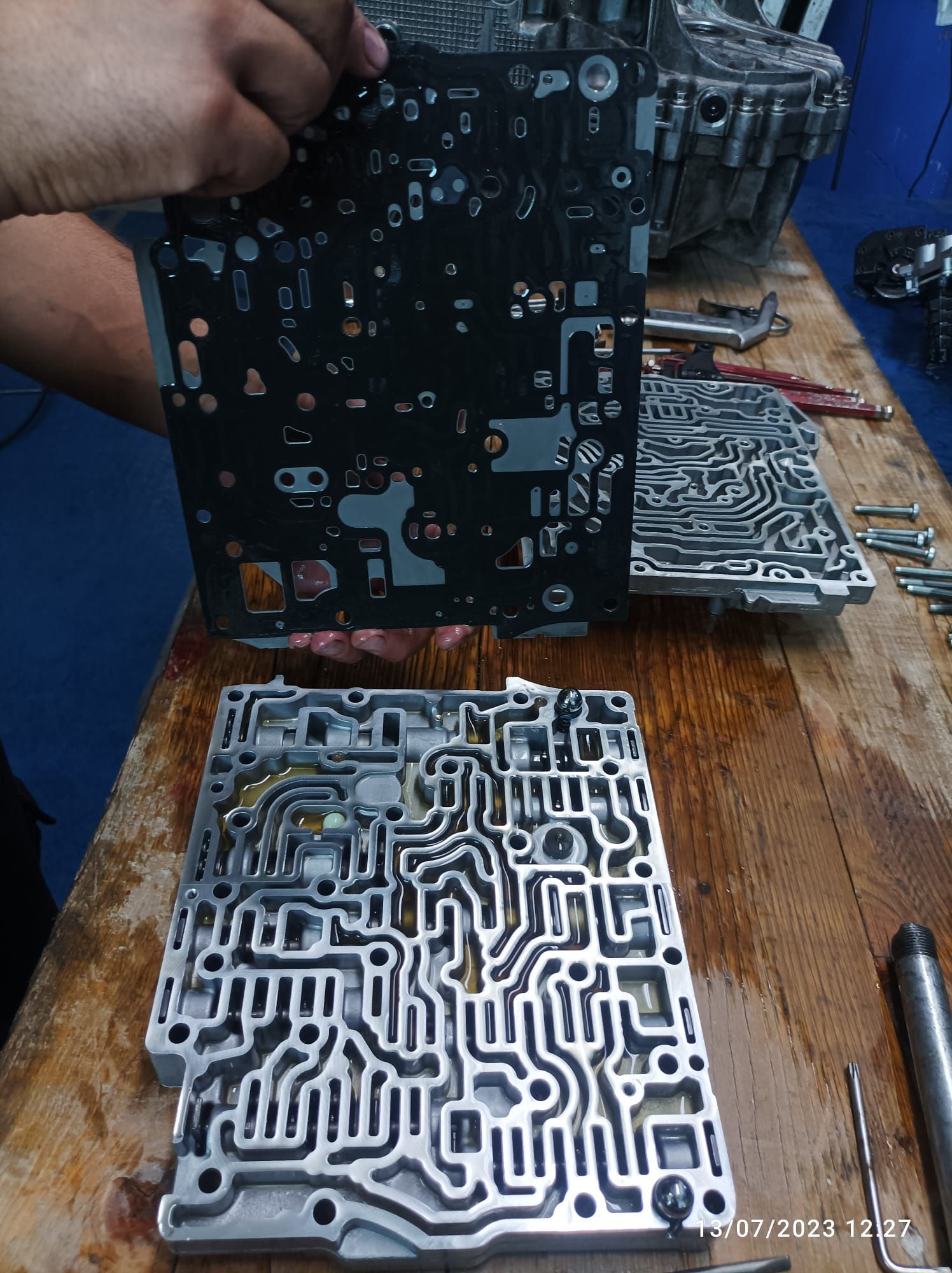 Un uomo tiene in mano un pezzo di metallo che sembra una scheda madre