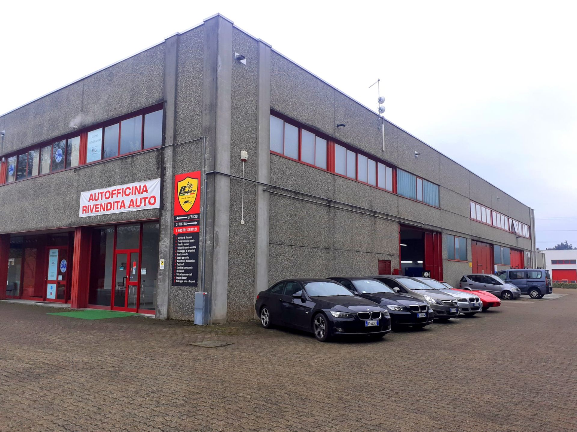 Una fila di auto è parcheggiata davanti a un edificio con la scritta supernova