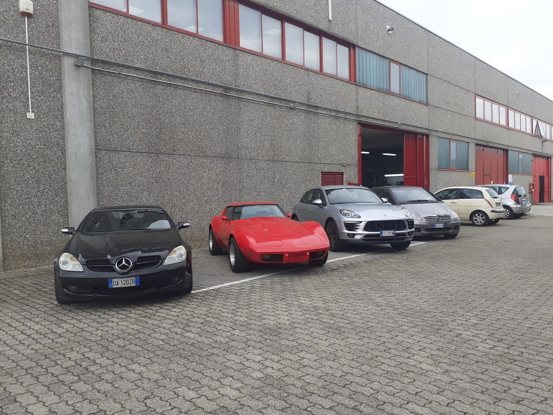 Una corvette rossa è parcheggiata davanti a un edificio