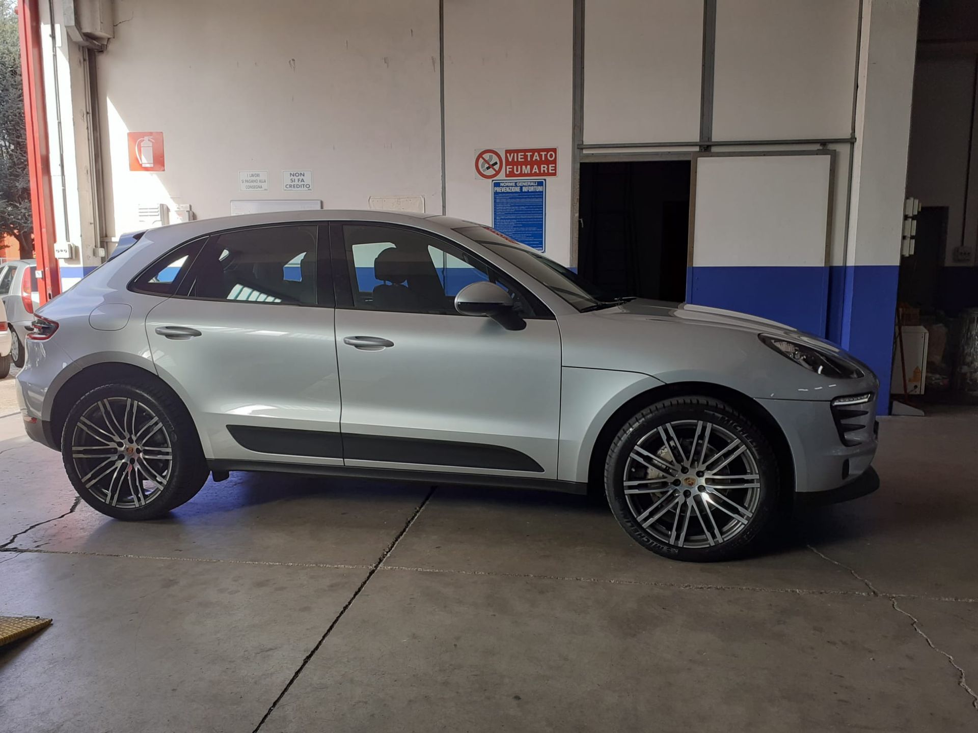 Una porsche macan turbo argentata è parcheggiata in un garage