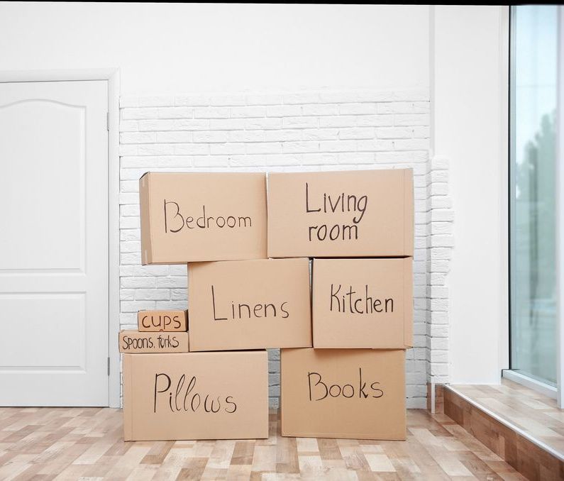 A Bunch Of Cardboard Boxes Are Stacked On Top Of Each Other In An Empty Room — Crichton Removals In North Geelong, VIC