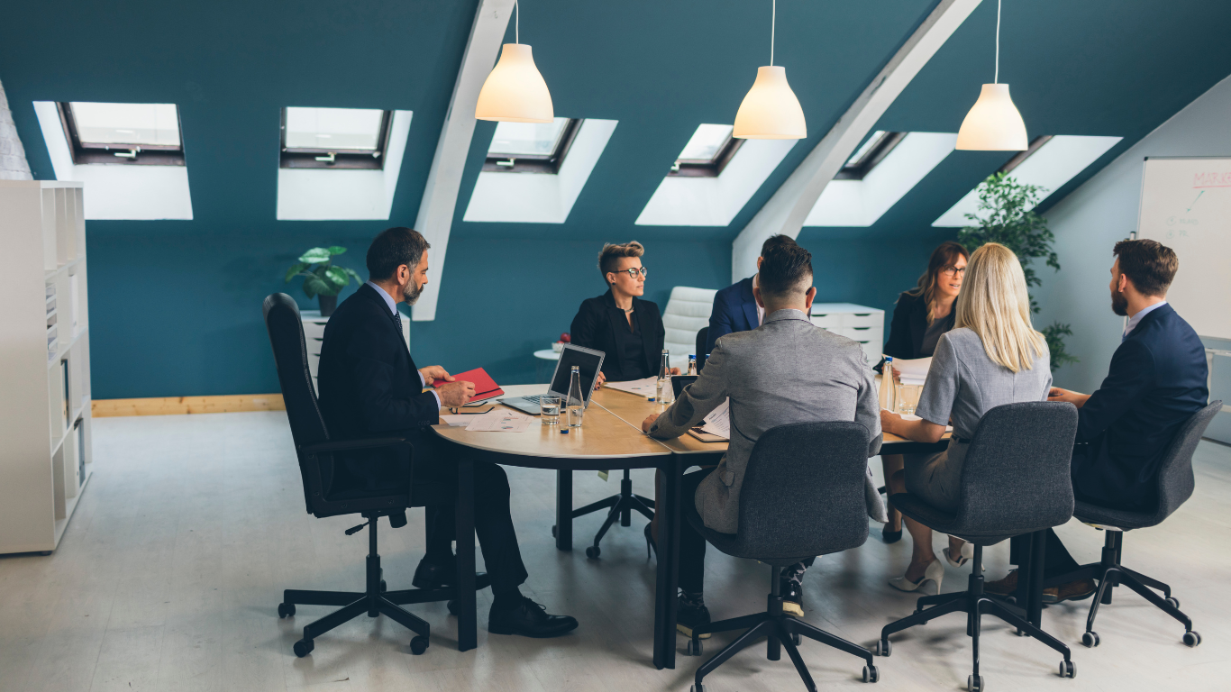 Business team in meeting around a round table in an office setting.