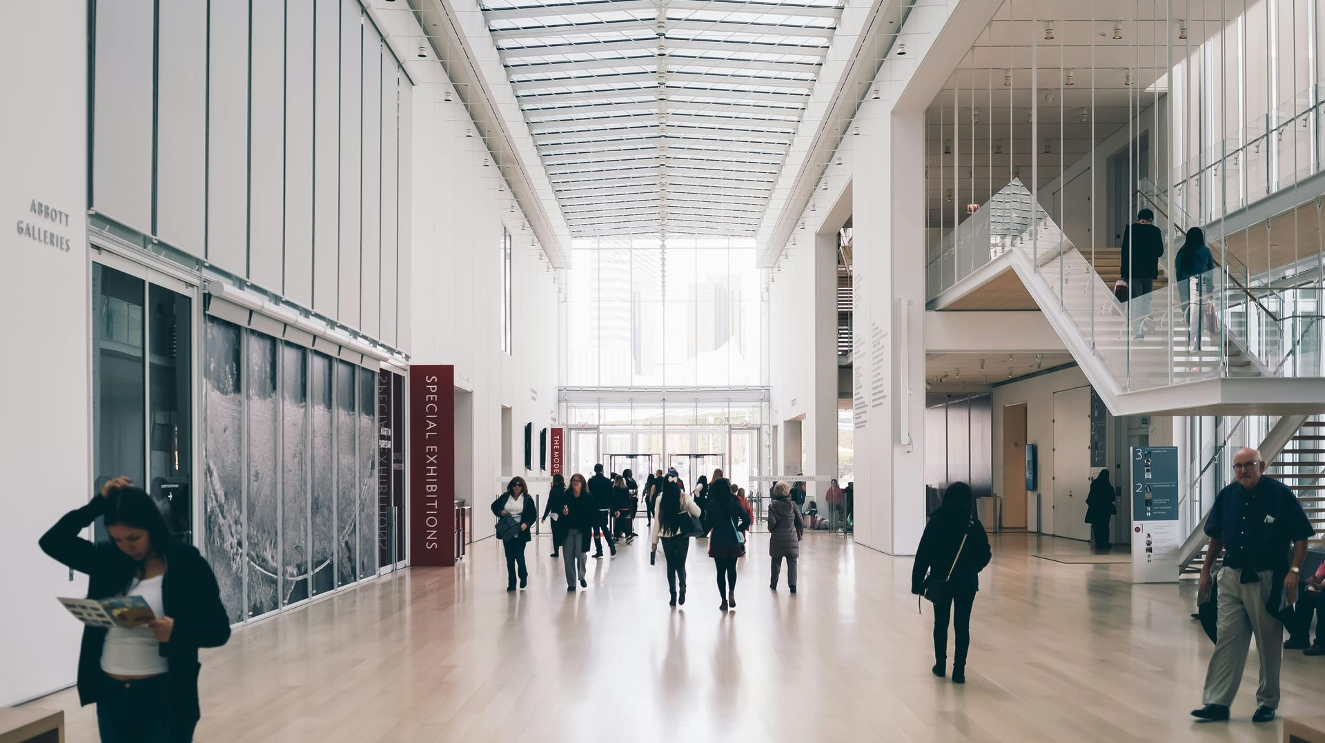 Large, bright museum interior with people walking; a skylight illuminates the space.