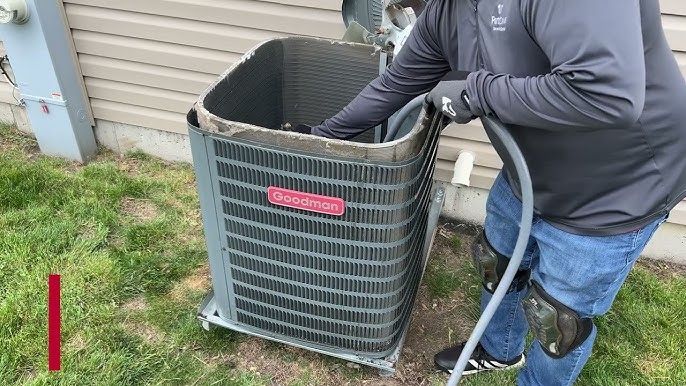 Person connecting pipes to an air conditioning unit.