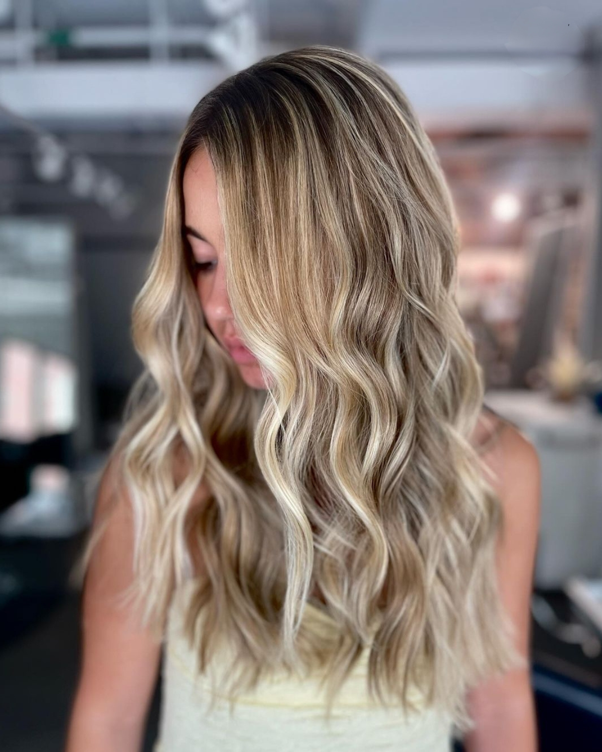 A woman with long blonde hair is standing in a room.