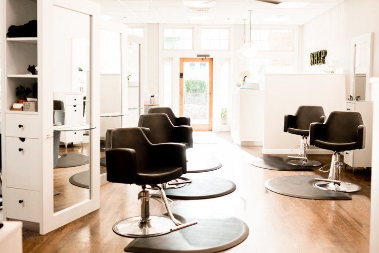 A hair salon with a lot of chairs and a mirror.