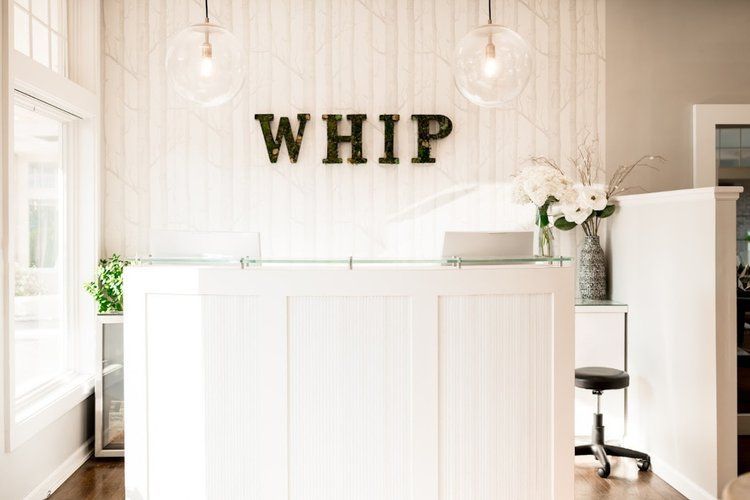 A white reception desk with the word whip written on it.