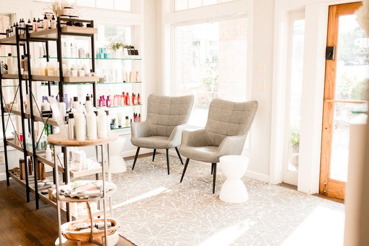 There are two chairs in the waiting room of a salon.