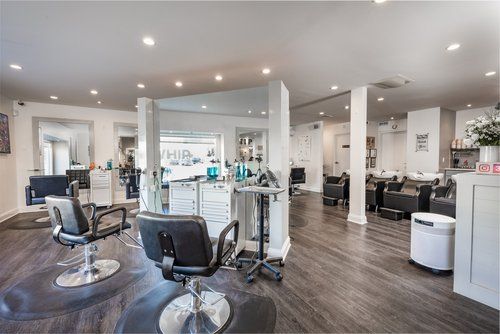 A large salon with lots of chairs and mirrors.