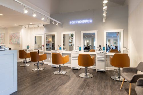 A hair salon with a lot of chairs and mirrors.