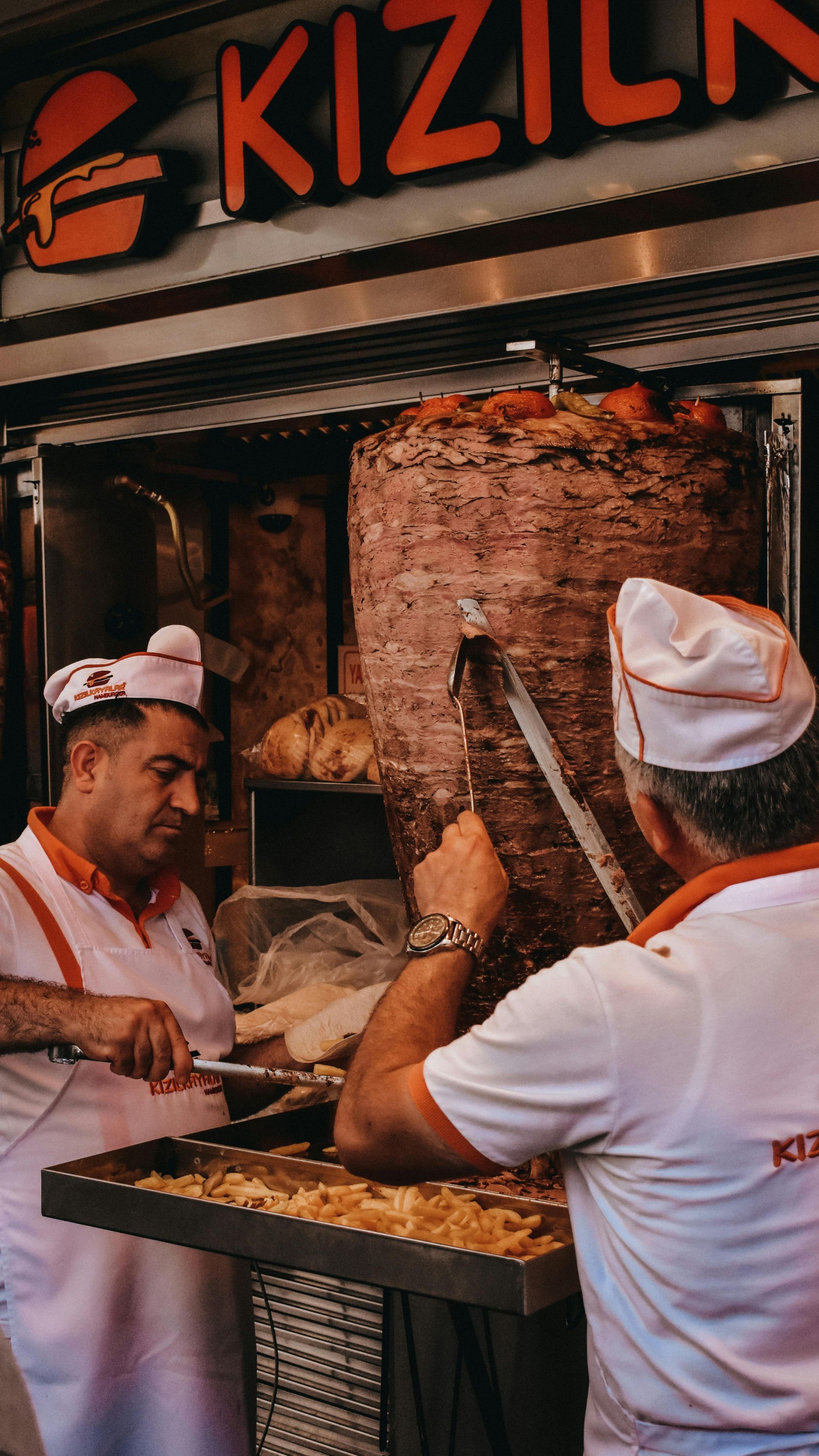 Two men carving Shawarma in a San Diego Food truck