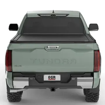 The back of a green tundra truck with a black bed cover.
