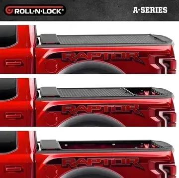 A red ford raptor truck with a roll n lock bed cover.