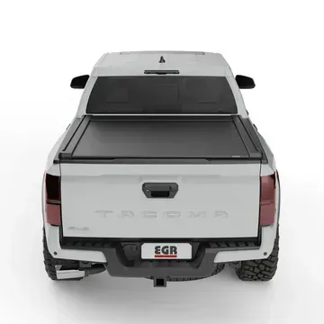 The back of a white tacoma truck with a black tonneau cover.