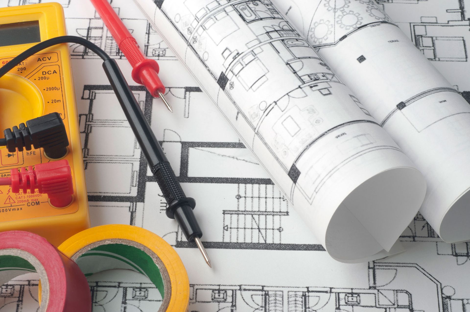 A yellow multi-meter is sitting on top of a blueprint