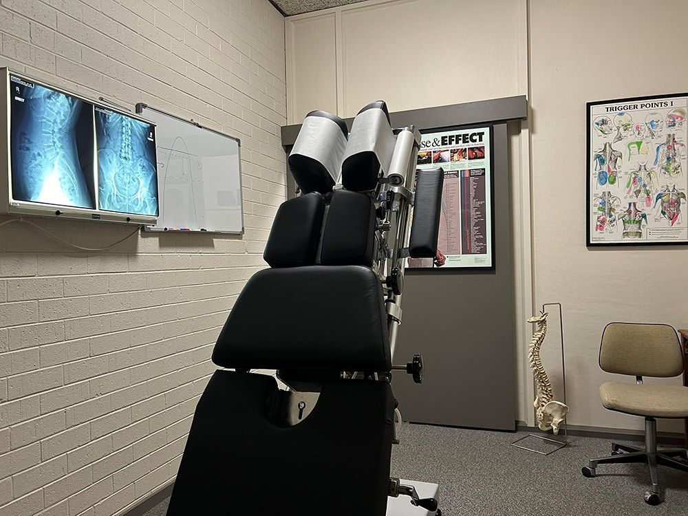 A Doctor 's Office With A Chiropractic Chair And X-Rays On The Wall — Cobargo Chiropractic in Cobargo, NSW