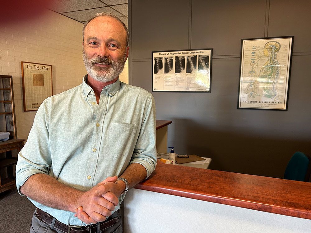 A Chiropractic Office With A Blue Building In The Background — Cobargo Chiropractic in Cobargo, NSW