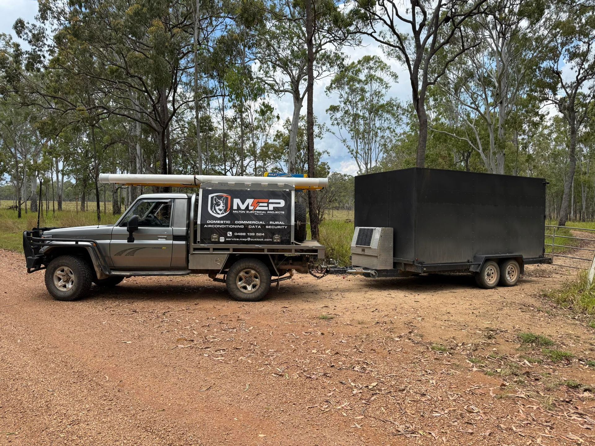 Silhouetted Utility Workers on a Power Pole Against a Blue Sky, Clouds — Milton Electrical Projects in Kaban, QLD