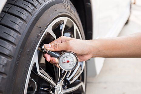 Auto Services — Mechanic Checking Tire Pressure in Detroit, MI