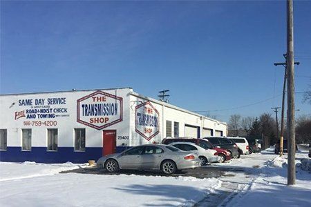 Engine Check — Cars Parked in Snowy Road in Front of Shop in Detroit, MI