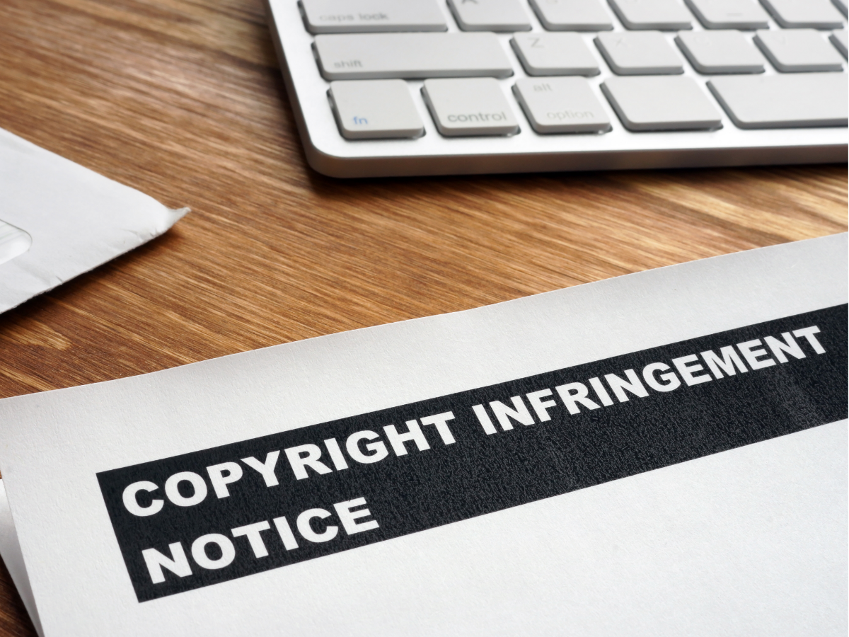 People at a table, reviewing documents. Papers, pens, and coffee cups are also present.