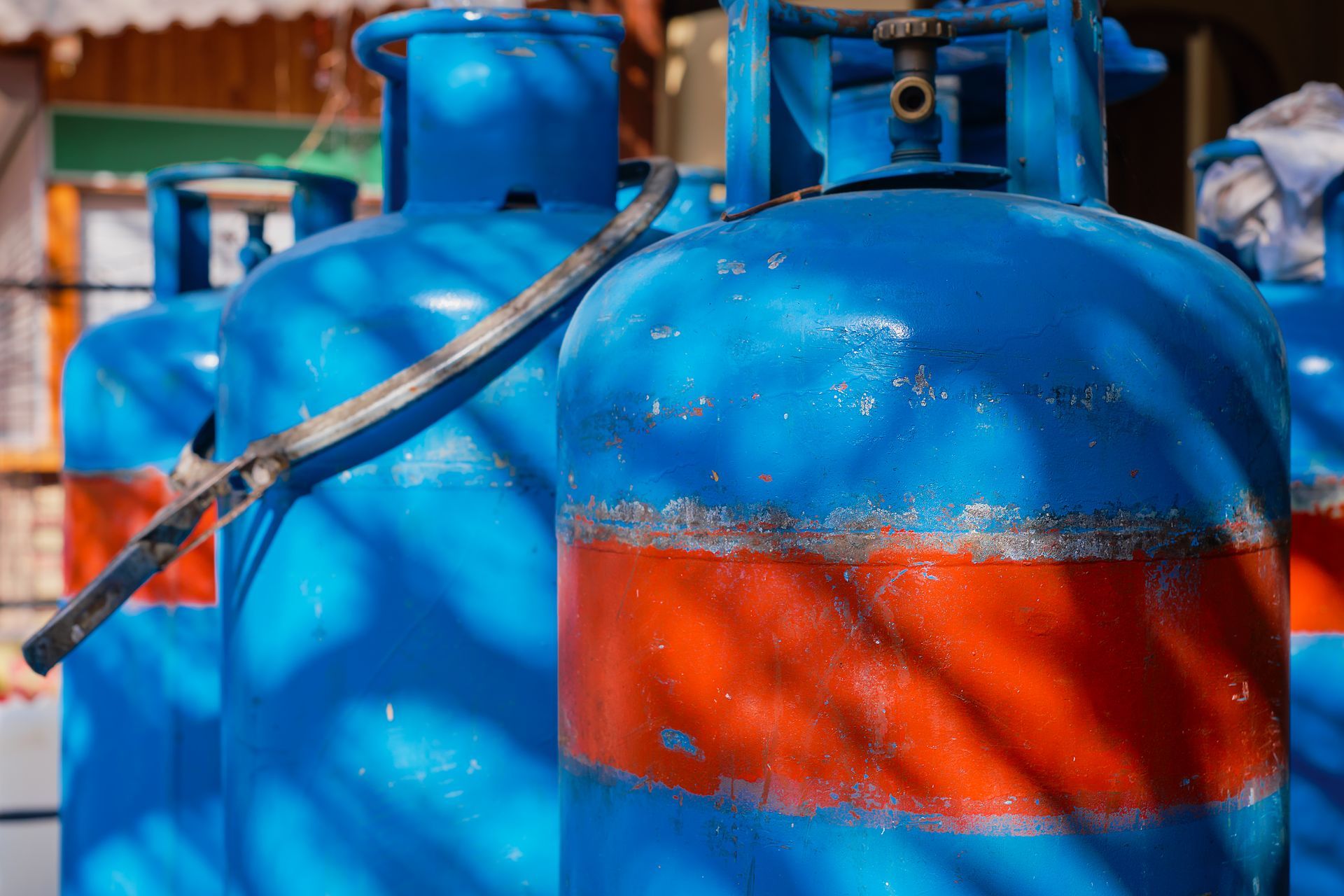 Blue and orange propane tanks lined up outside.