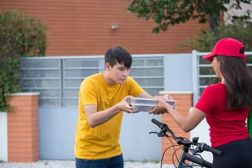 Man in yellow t-shirt receiving online food delivery order