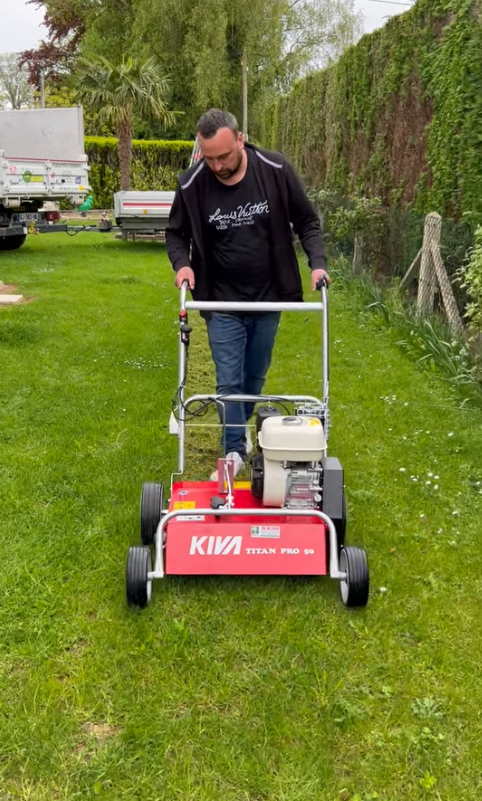 Baptiste Dezailles pousse une tondeuse à gazon sur une pelouse verte luxuriante.