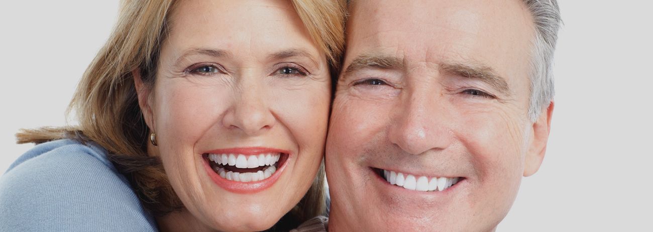 A Man and a Woman Are Smiling for the Camera — Yeppoon Denture Clinic in Taranganba, QLD