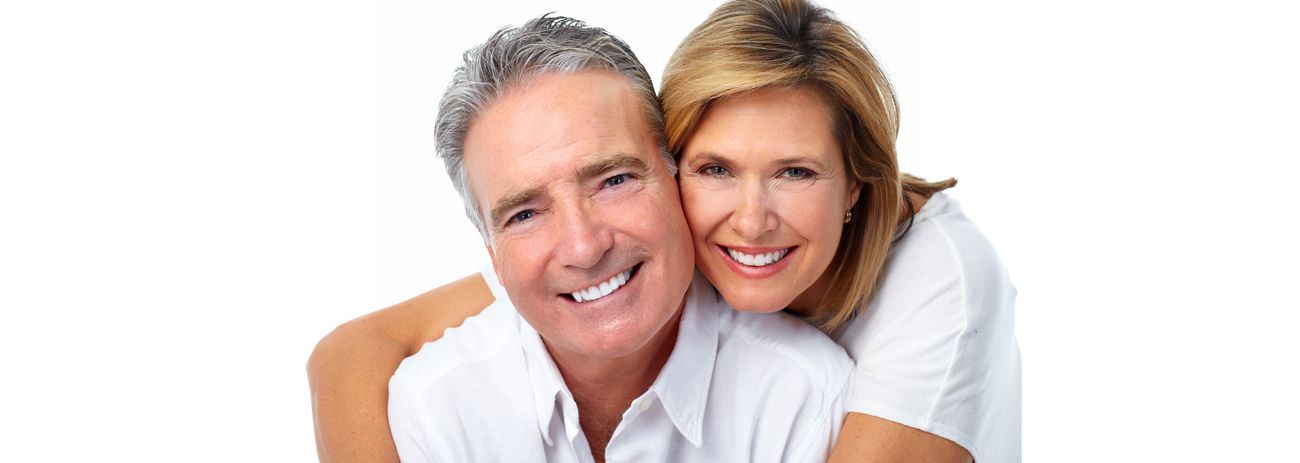 A Man and a Woman Are Hugging Each Other and Smiling — Yeppoon Denture Clinic in Taranganba, QLD