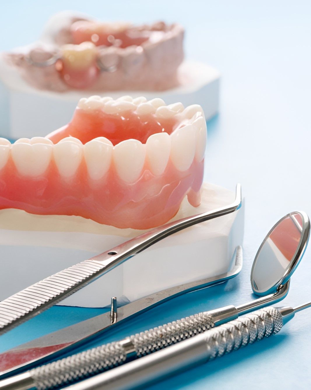 A Pair of Dentures and Dental Instruments on a Blue Surface — Yeppoon Denture Clinic in Taranganba, QLD