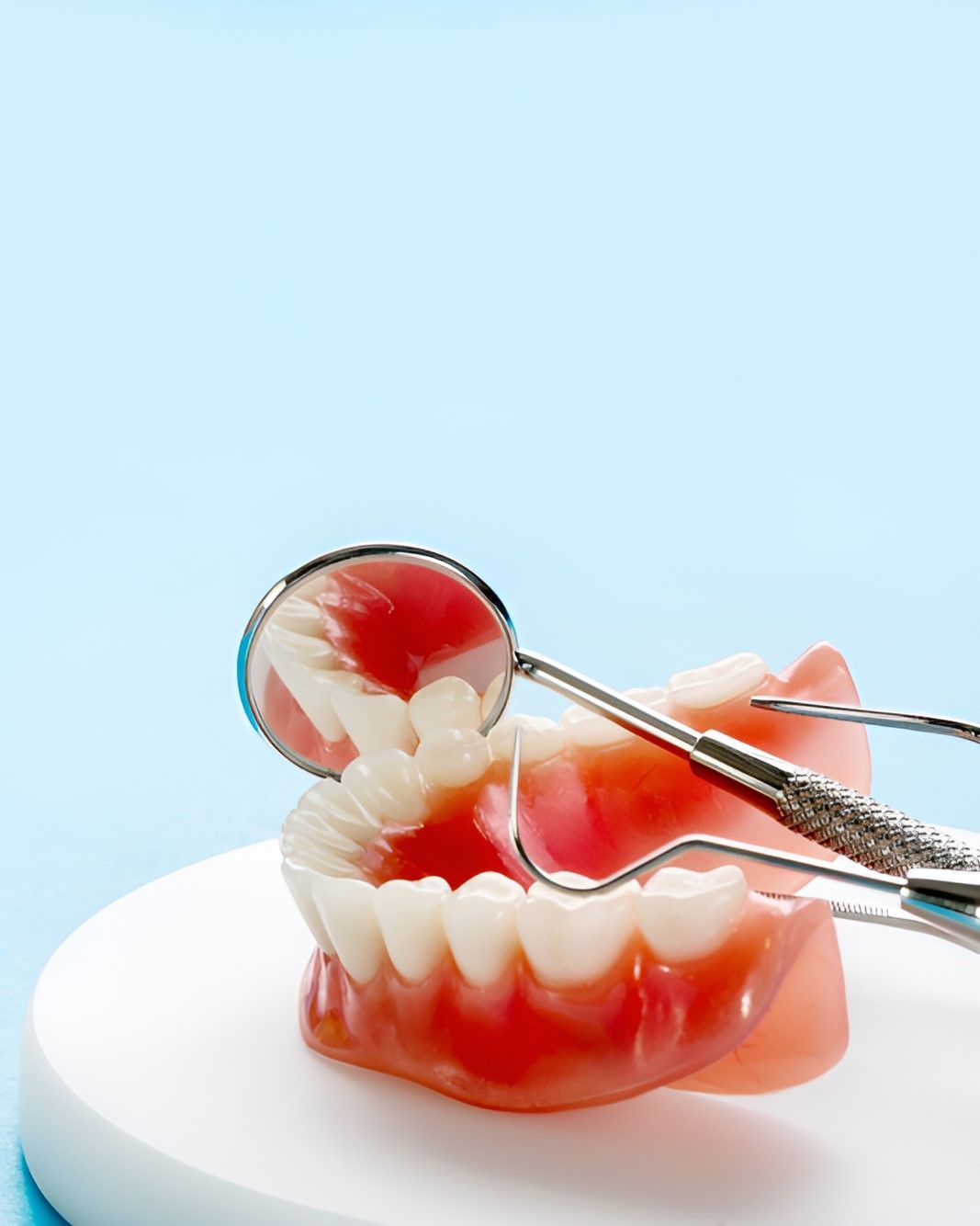 A Fake Mouth With a Dental Mirror and Tweezers on It — Yeppoon Denture Clinic in Rockhampton, QLD