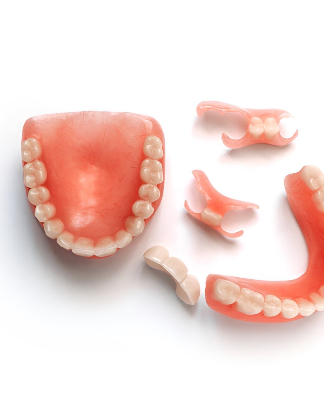 A Denture is Broken Into Pieces on a White Surface — Yeppoon Denture Clinic in Taranganba, QLD