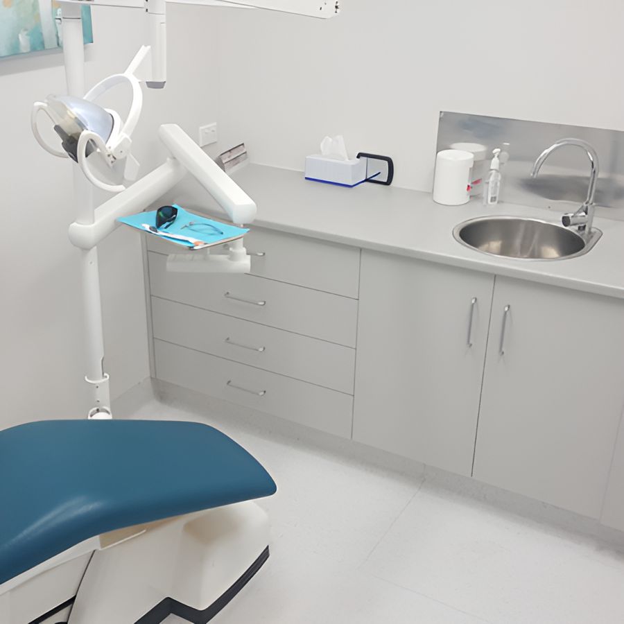 A Dental Office With a Blue Chair and a Sink — Yeppoon Denture Clinic in Taranganba, QLD
