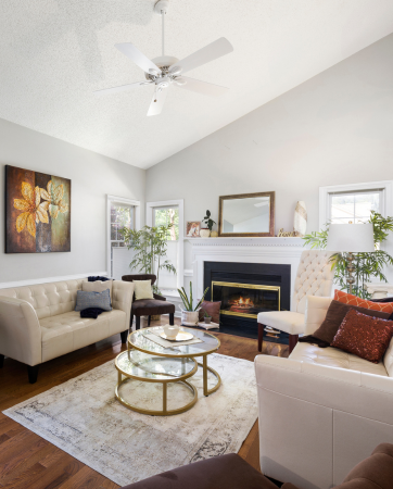 Roofers installing dark gray shingles on a roof under a bright blue sky.