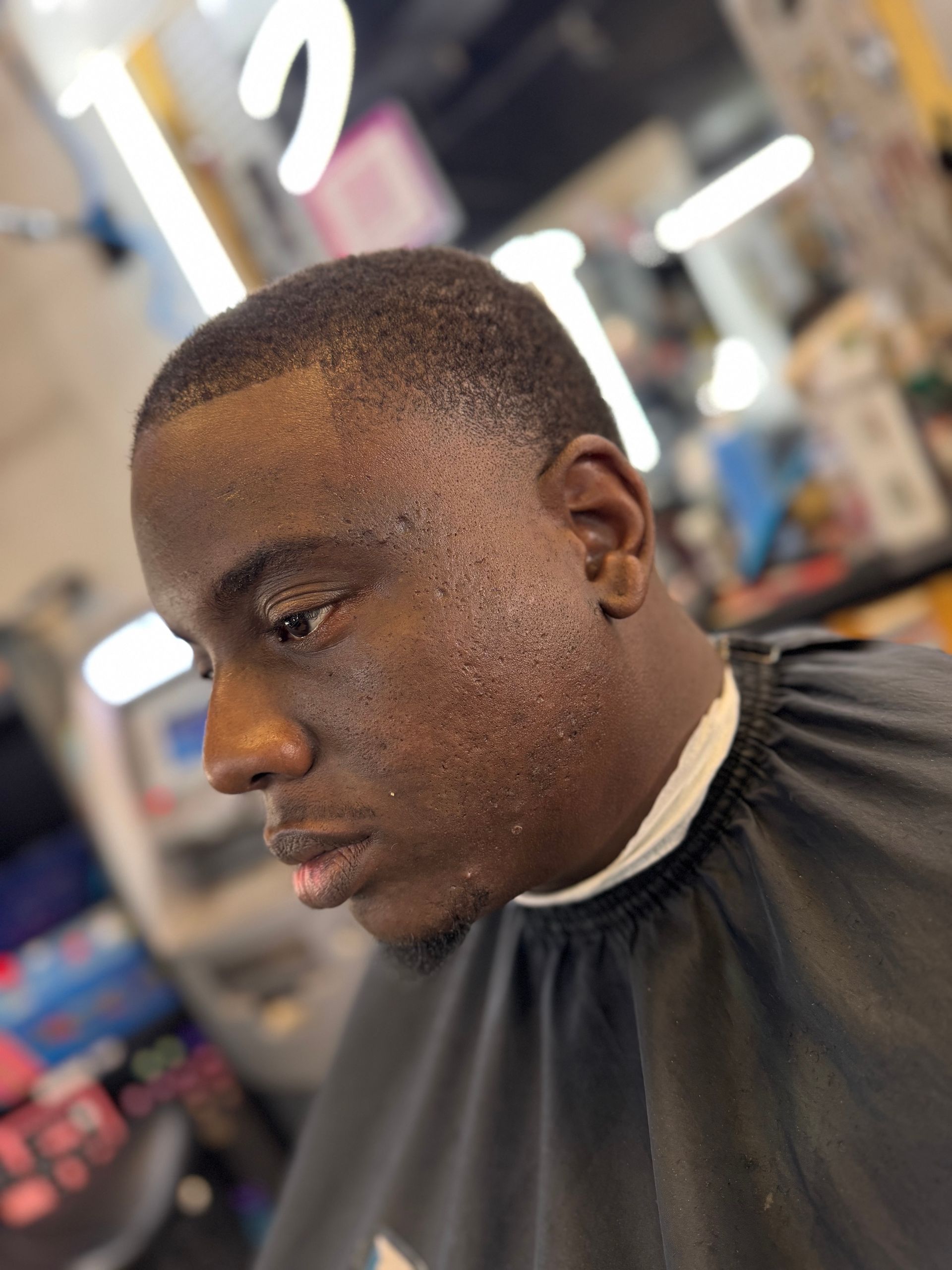 A man is getting his hair cut at a barber shop.