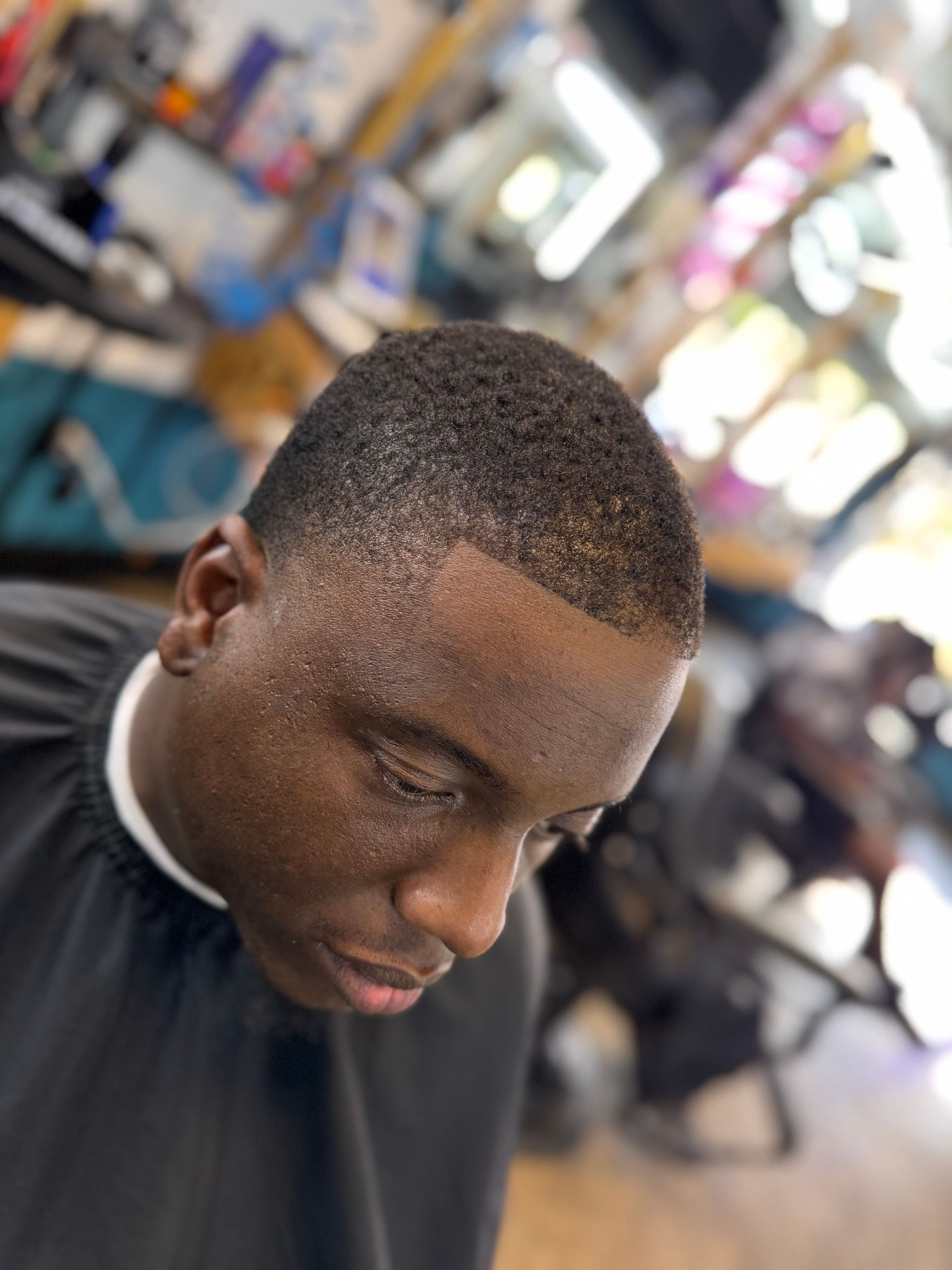 A man is getting his hair cut at a barber shop.