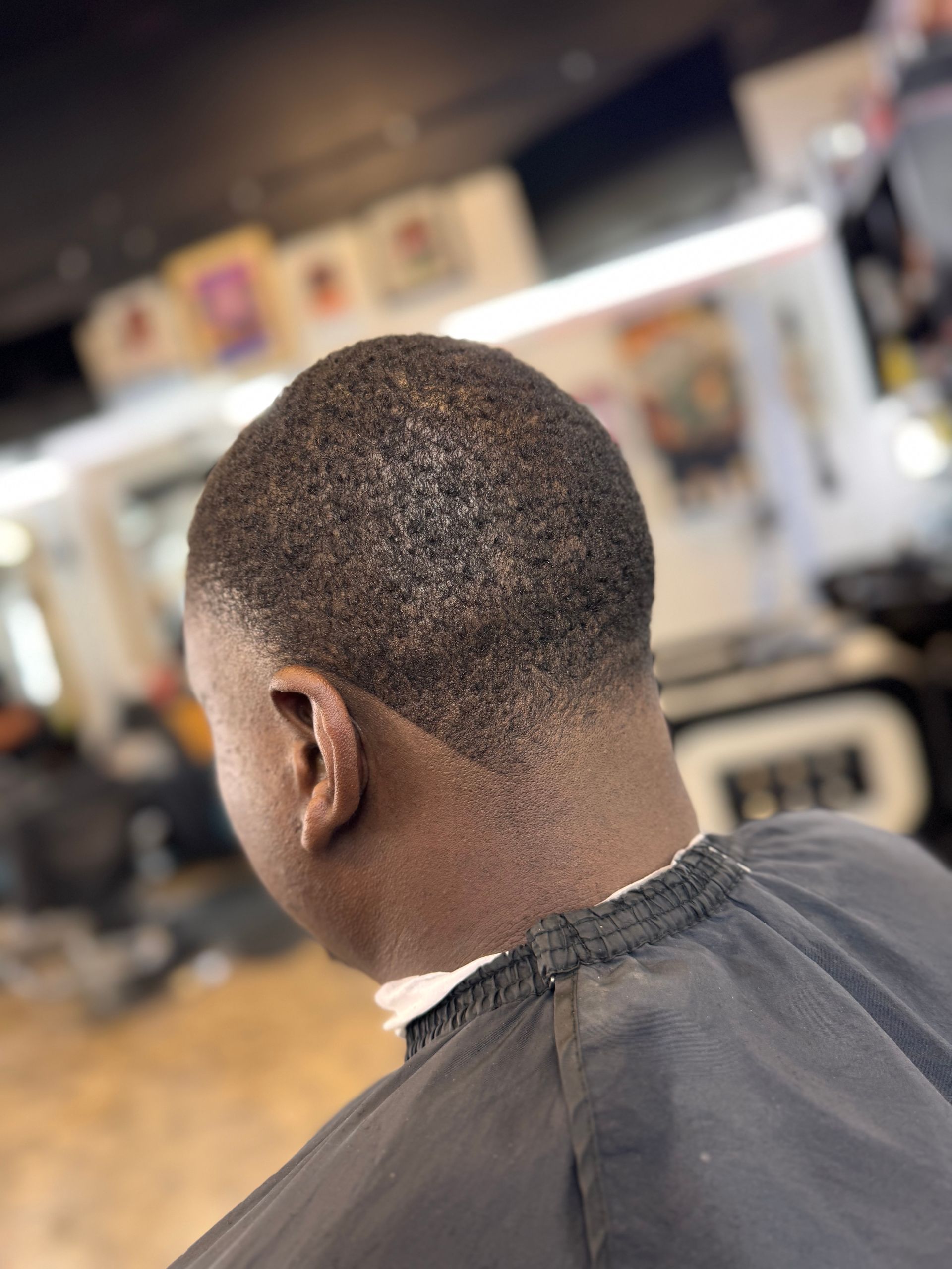 A man is getting his hair cut at a barber shop.