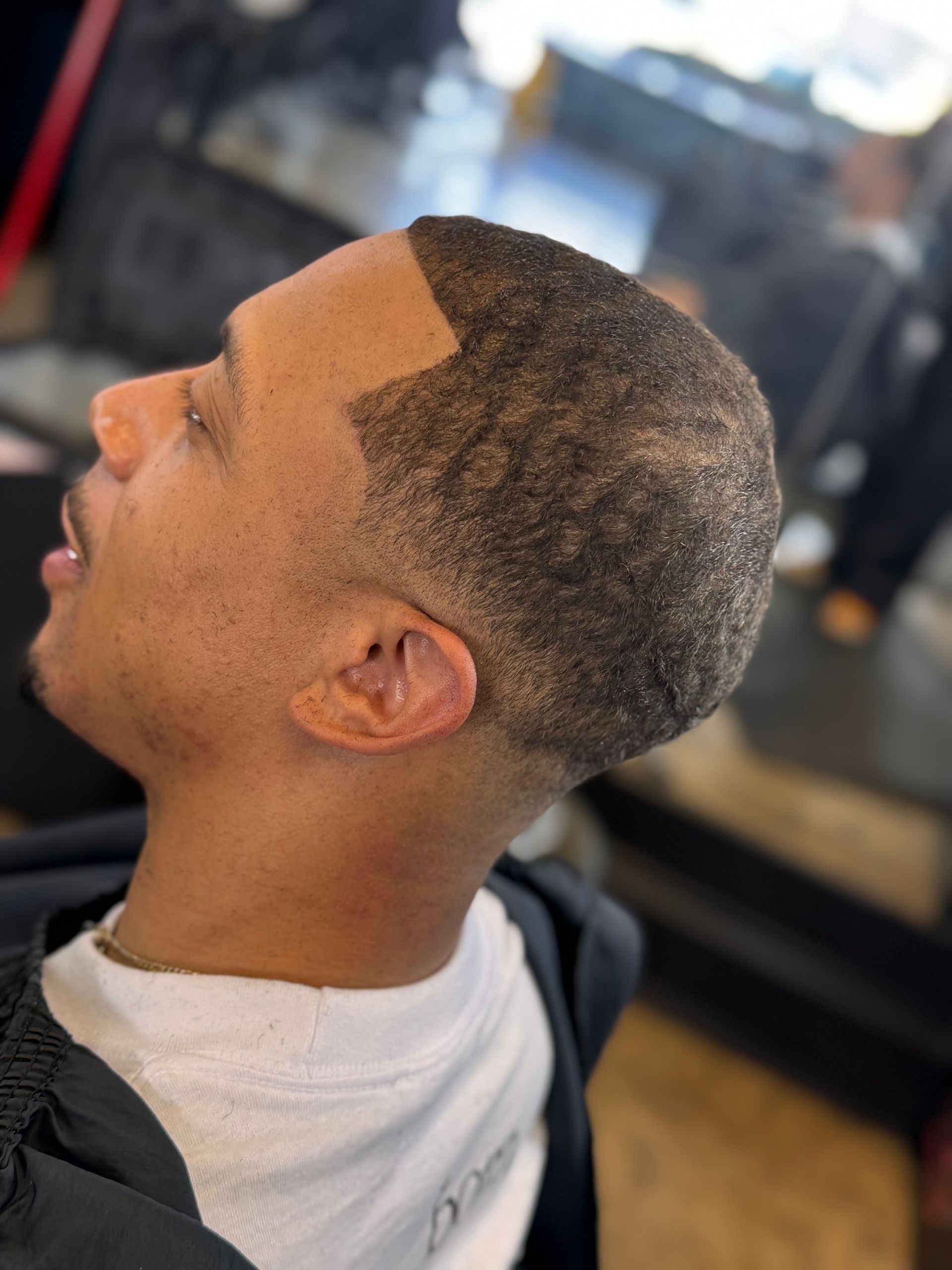 A man is getting his hair cut at a barber shop