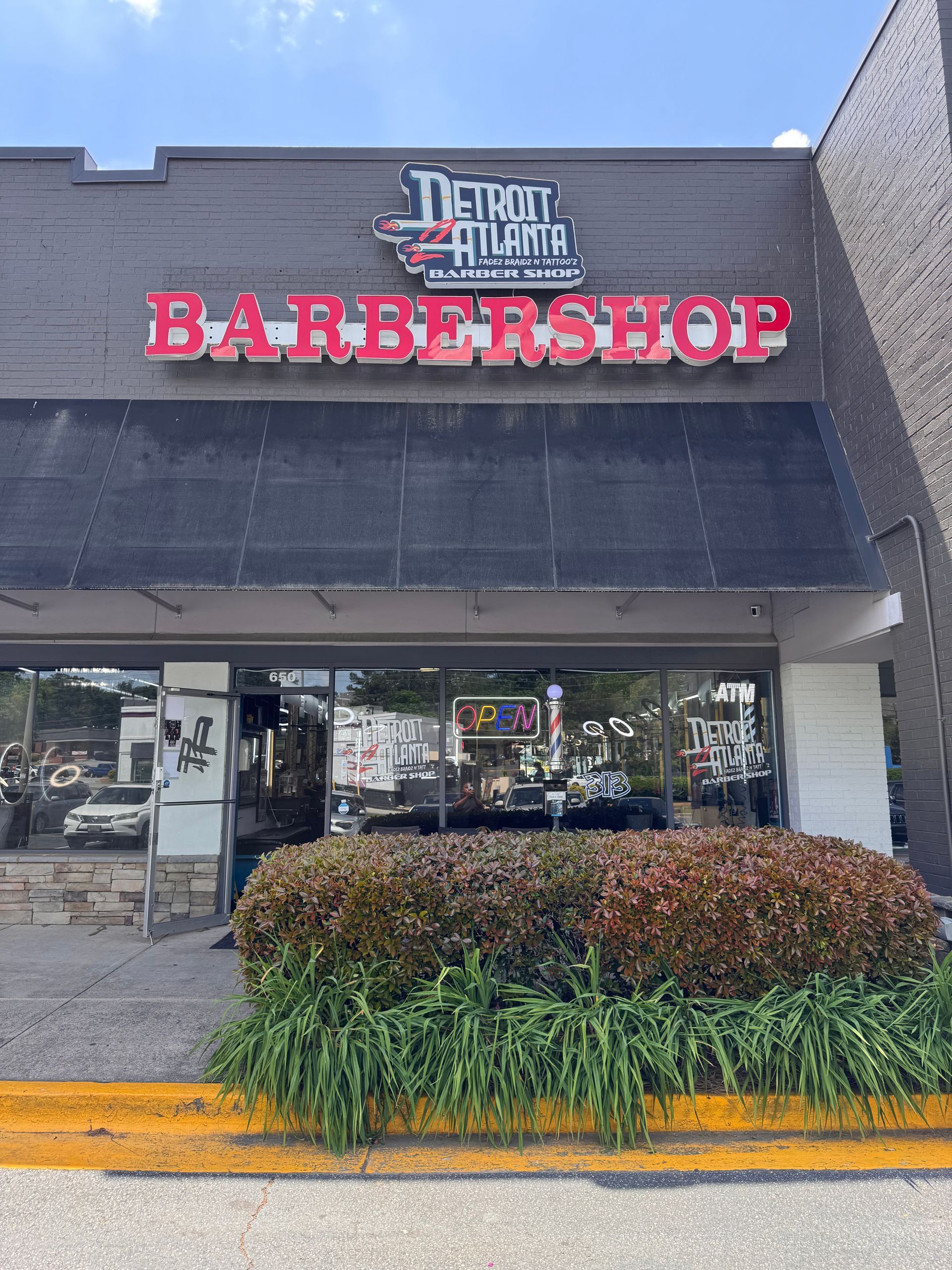 The front of a barber shop with a sign that says barbershop on it.