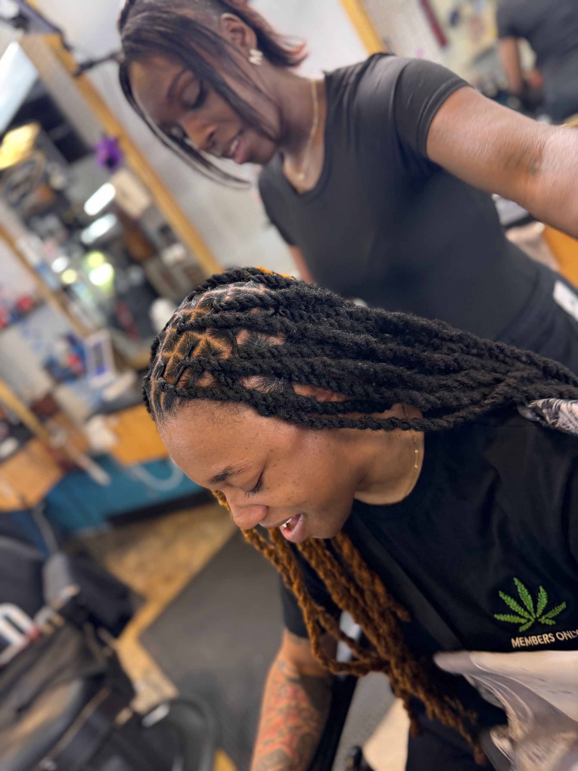 A woman is getting her hair done by a hairdresser in a salon.