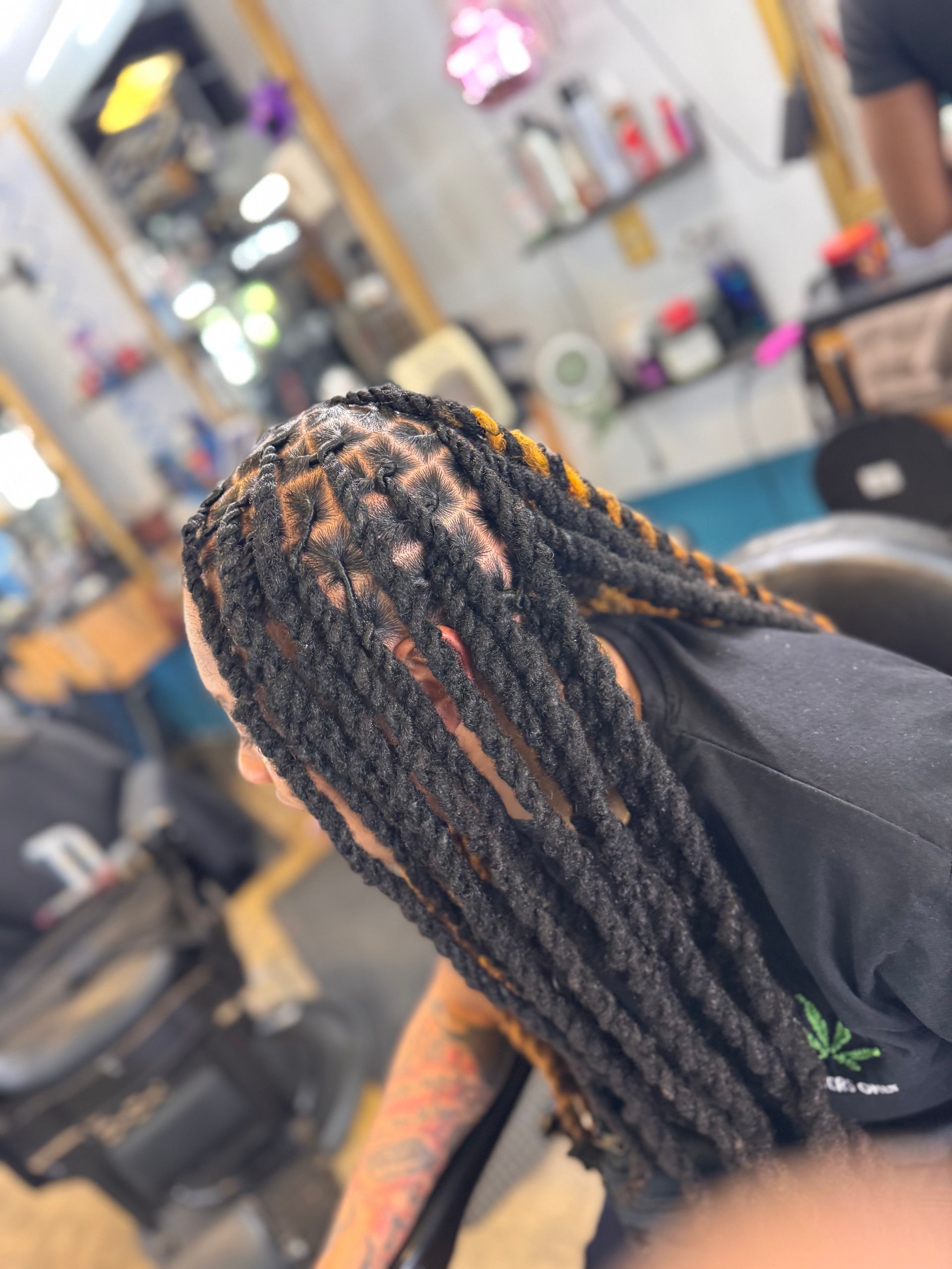 A woman with dreadlocks is sitting in a chair in a salon.