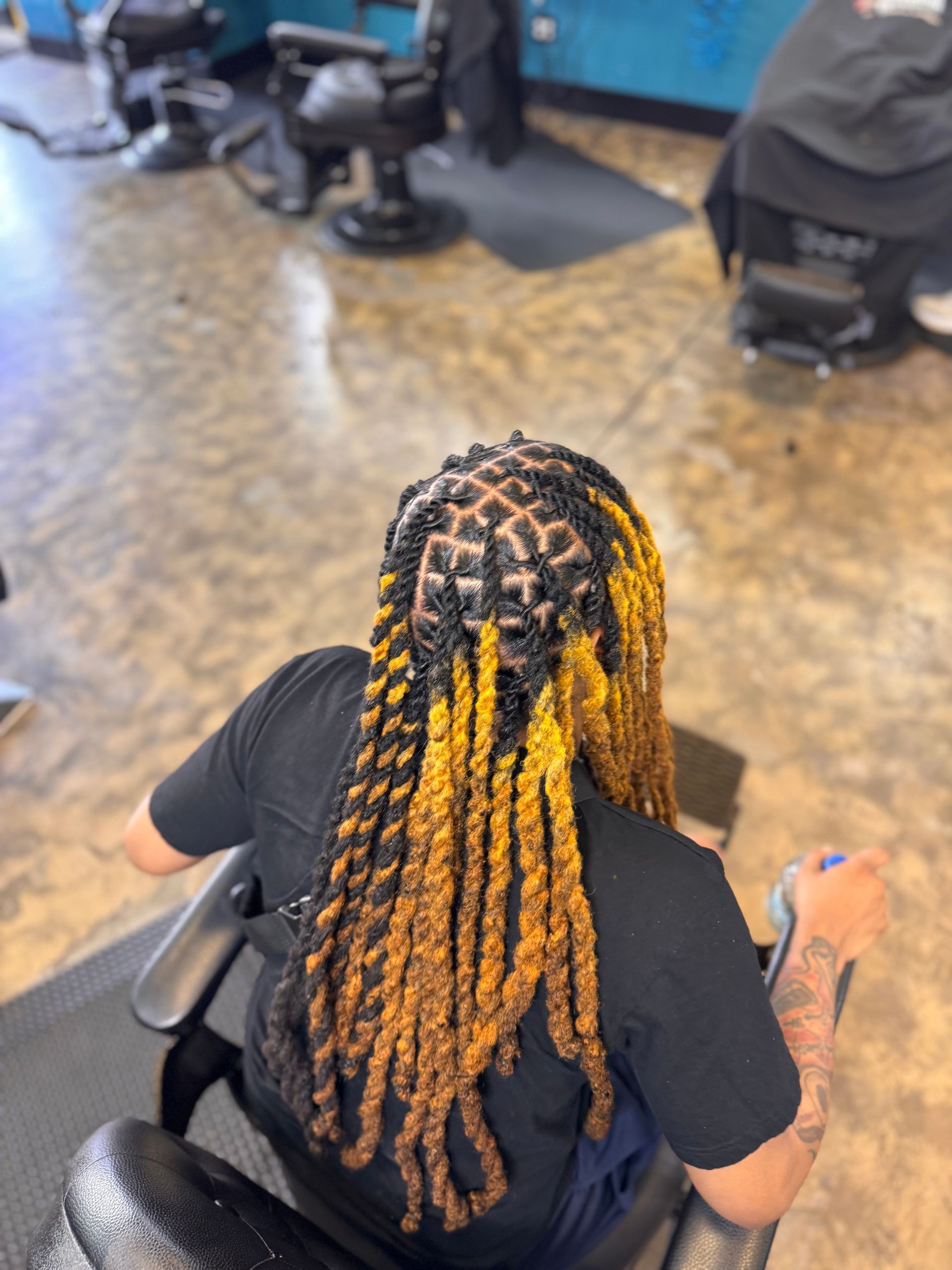A woman with dreadlocks is sitting in a chair in a salon.