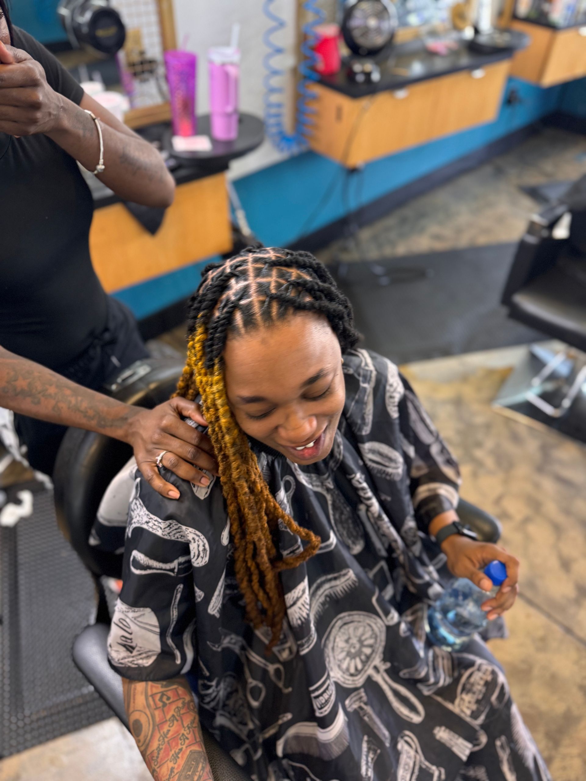 A woman is getting her hair cut at a barber shop.