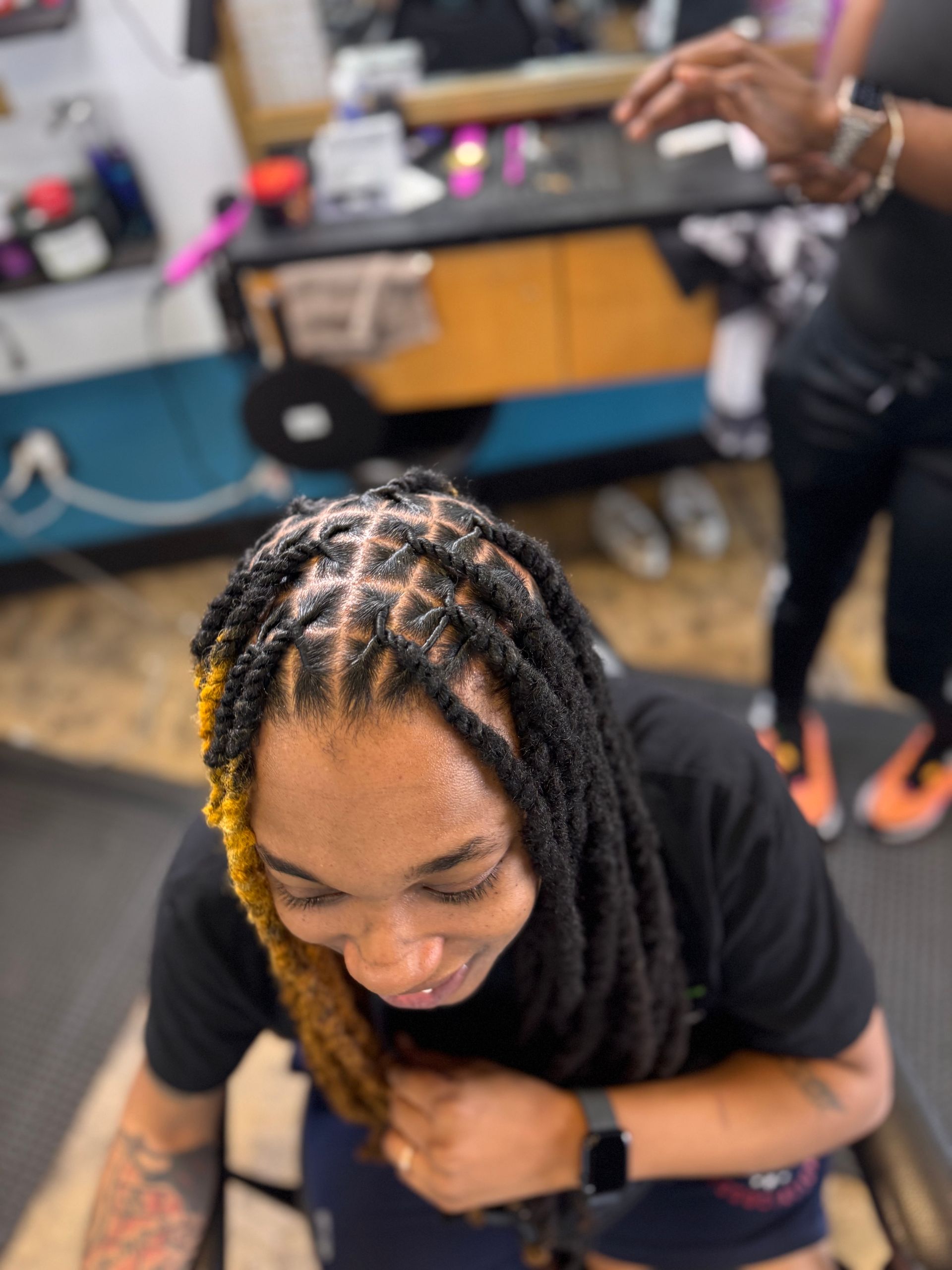 A woman with dreadlocks is sitting in a chair in a salon.