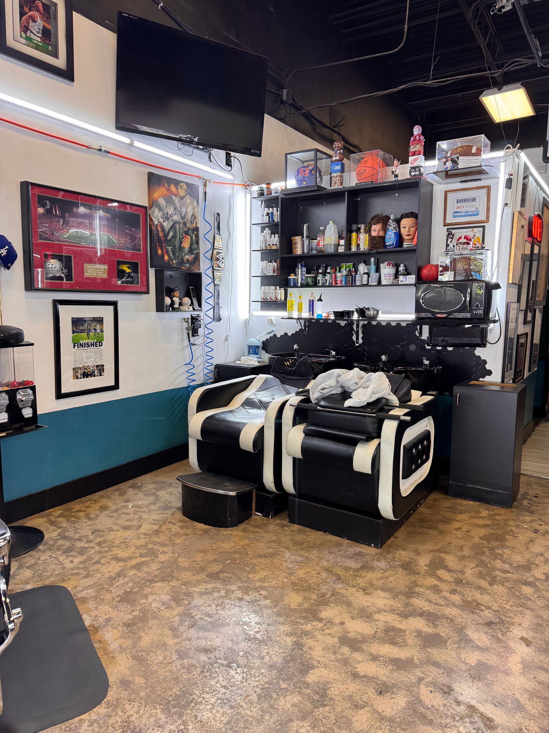 A barber shop with a couch and a sink.