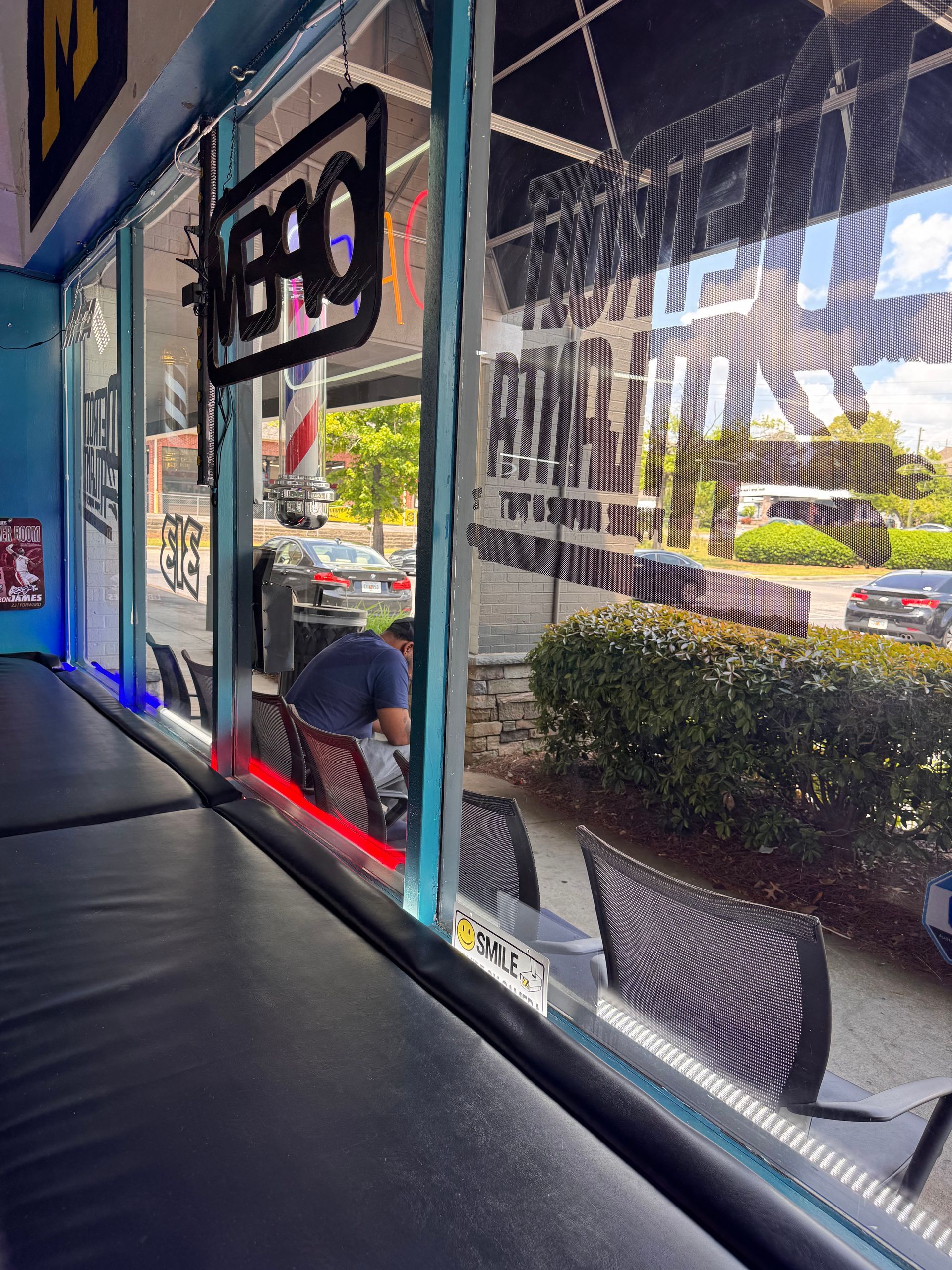 A man is sitting at a table in front of a window in a restaurant.